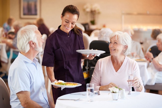 Seniors Enjoying being served in dining room
